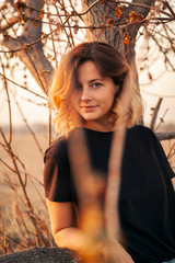 Outdoor atmospheric lifestyle photo of young beautiful  darkhaired woman  brown knit sweater made of natural wool and jeans in sunny autumn day, on background field