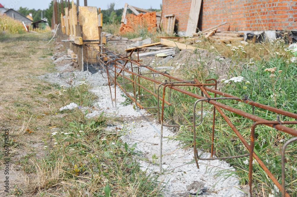 Building concrete foundation for new fence with reinforcing bars and ...
