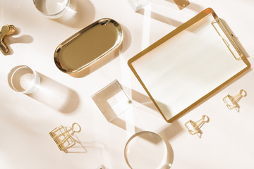 Knolling grid flatlay scene, white planner and gold stationery accessories, on a white desk background