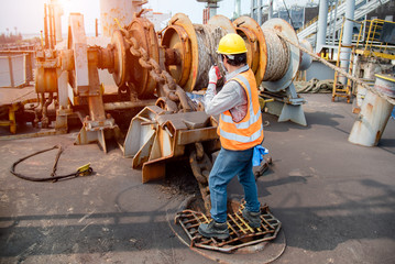 engineering or worker, motor man, loading master controller working in communication by walkie talkie to the team for safety loading winch of the crane, lifting gears operation in industrial work site