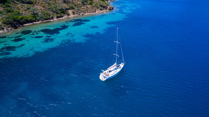 Poster - Aerial view of sea and yacht. Sailing ship in the middle of ocean, top view, summer background. Amazing view to Yacht sailing in open sea at sunny day