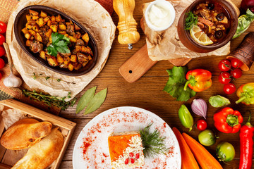 Top view image of traditional georgian lunch with various meals and ingredients at decorated wooden table background.