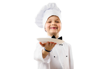 Wall Mural - cute funny boy chef in uniform holds a clean empty white plate in his hand