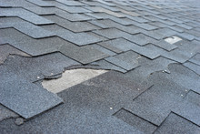 Сlose Up View Of Asphalt Shingles Roof Damage That Needs Repair.