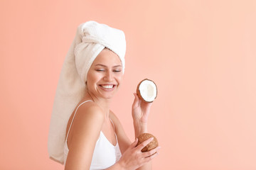 Wall Mural - Beautiful young woman with coconut on color background