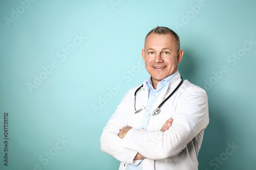 Handsome middle-aged doctor on color background Poster Mural XXL