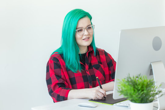 Graphic designer, animator and illustrator concept - young woman with green hair working at the laptop