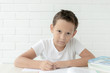 © Delete - The boy teaches lessons , prepares for school writes and reads textbooks on a white background