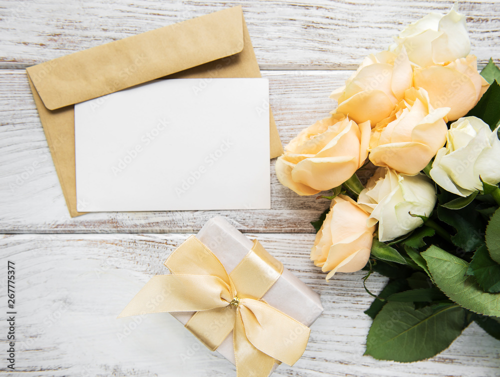 White roses and greeting card on a old wooden table - obrazy, fototapety, plakaty 