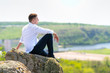 © kolotype - Attractive smart man sitting relaxing on a rock