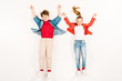 © LIGHTFIELD STUDIOS - top view of cheerful kids with hands above head lying on white