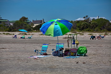 Sticker - Empty colorful beach chairs in the sand under an umbrella