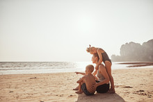 Loving Family Looking At The Ocean From A Sandy Beach