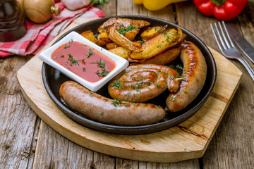 Sticker - assorted sausages with sauces on wooden background