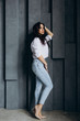 © dimadasha - Photo session of a young brunette in jeans and a white shirt.