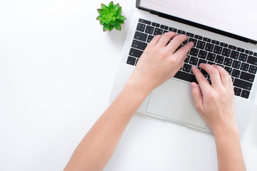 Poster - Human hands on a modern style white desk with a laptop computer top view.
