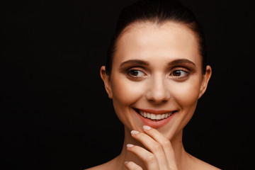 Wall Mural - Portrait of a beautiful woman with collected hair and bare shoulders on a black background