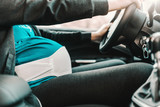 Fototapeta Konie - Close up of pregnant woman driving car. Hands on steering wheel.