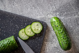 Fototapeta  - Ogórek zielony gruntowy, na desce do krojenia z nożem
