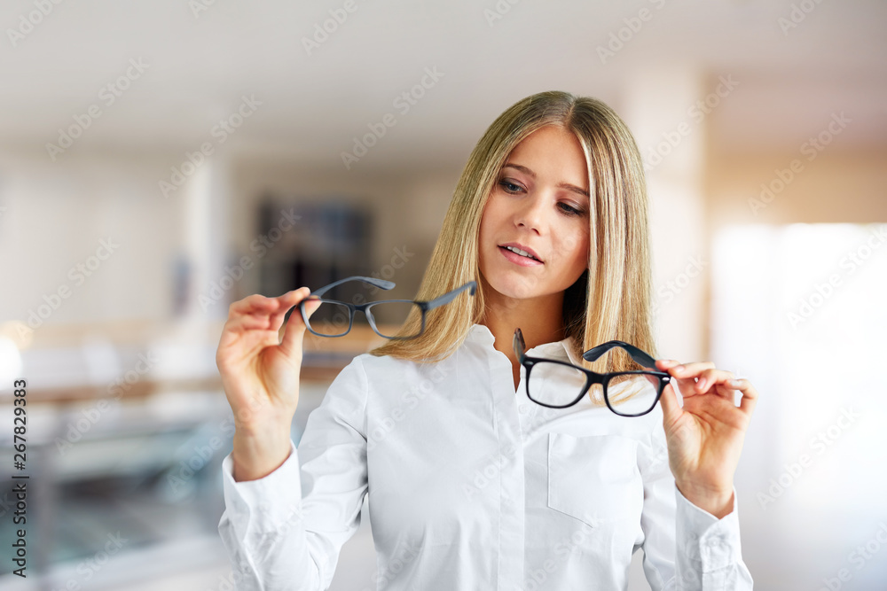 Pensive woman with glasses in a business center - obrazy, fototapety, plakaty 
