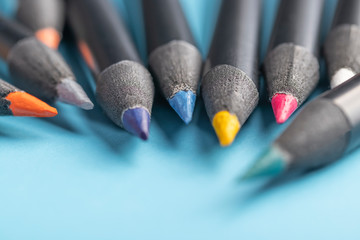 Wall Mural - A group of multicolored wood pencils in a black case against a blue background