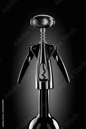 Fotografía Chrome plated corkscrew on the bottle neck a dark background
