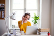 © Halfpoint - A young female student sitting at the table, using laptop when studying.