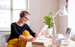 © Halfpoint - A young female student sitting at the table, using tablet when studying.