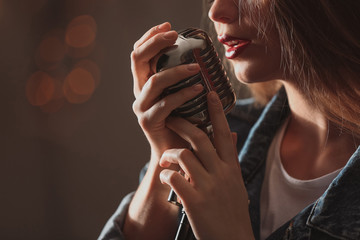 Beautiful female singer with microphone on stage, closeup