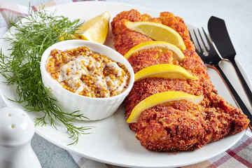 Sticker - Breaded hake fillet served on a white plate