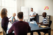 © Flamingo Images - Smiling manager talking to staff during a whiteboard presentatio