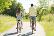 © Syda Productions - people, leisure and lifestyle concept - young couple riding bicycles along road in summer