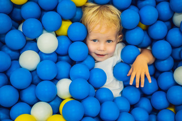 Child playing in ball pit. Colorful toys for kids. Kindergarten or preschool play room. Toddler kid at day care indoor playground. Balls pool for children. Birthday party for active preschooler