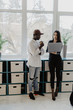 © F8  \ Suport Ukraine - African business man and caucasian woman with laptop in a modern business center.