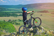 © Daniel CHETRONI - Little child stand next to his mountain bike on mountains edge and looks at the beautiful scenery