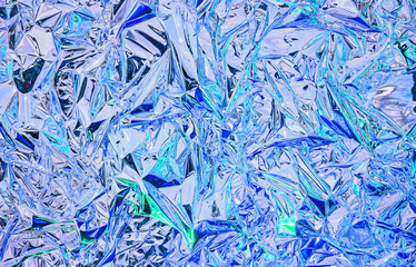 Aluminum foil with multi-colored illumination . Background and texture of aluminum foil.