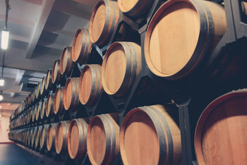 Fototapete - Oak barrels with cognac in dark cellar. Modern production of cognac with the observance of age-old traditions. close-up
