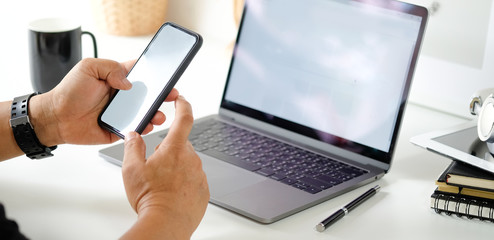 Wall Mural - Man using mobile smartphone in office workspace