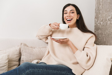 Wall Mural - Happy young girl relaxing on a couch