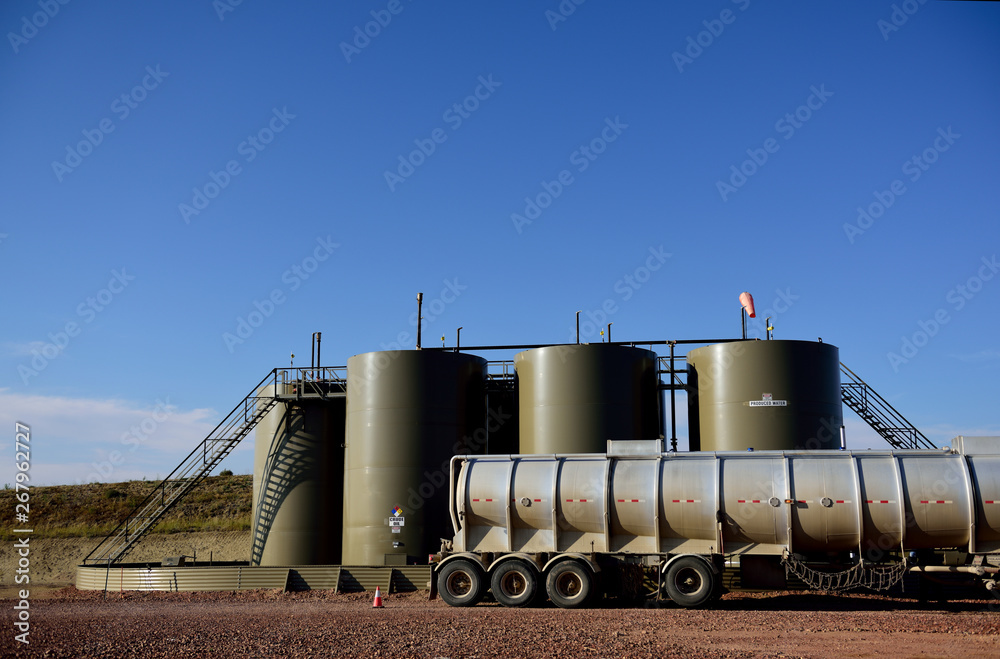 Oil tanker truck loading crude oil for transport, well site production ...