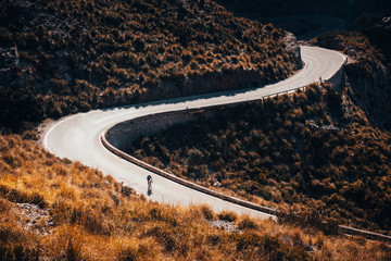 Sticker - Road biker silhouette on the road in mountains. Sport cycling photo.