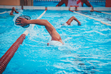 Two swimmers are practising swimming in the pool.