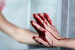 © LIGHTFIELD STUDIOS - partial view of woman with bleeding hand touching mirror in bathroom