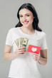© LIGHTFIELD STUDIOS - beautiful smiling girl holding dollar banknotes and red paper cut card with heart symbol isolated on grey