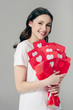 © LIGHTFIELD STUDIOS - happy pretty girl holding bouquet of red paper cut cards with hearts symbols and looking at camera isolated on grey