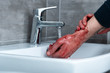 © LIGHTFIELD STUDIOS - partial view of man washing bleeding hands in sink