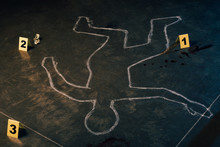 Chalk Outline And Evidence Markers At Crime Scene