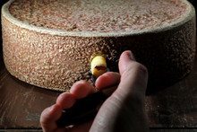 Organic Hay Milk Cheese Wheel From German Allgäu Region With Grading Iron In Ripening Storage