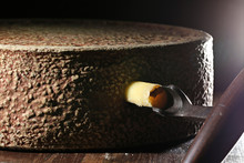 Organic Hay Milk Cheese Wheel From German Allgäu Region With Grading Iron In Ripening Storage