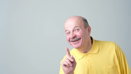 Poster - Satisfied mature man showing index finger up, giving advice